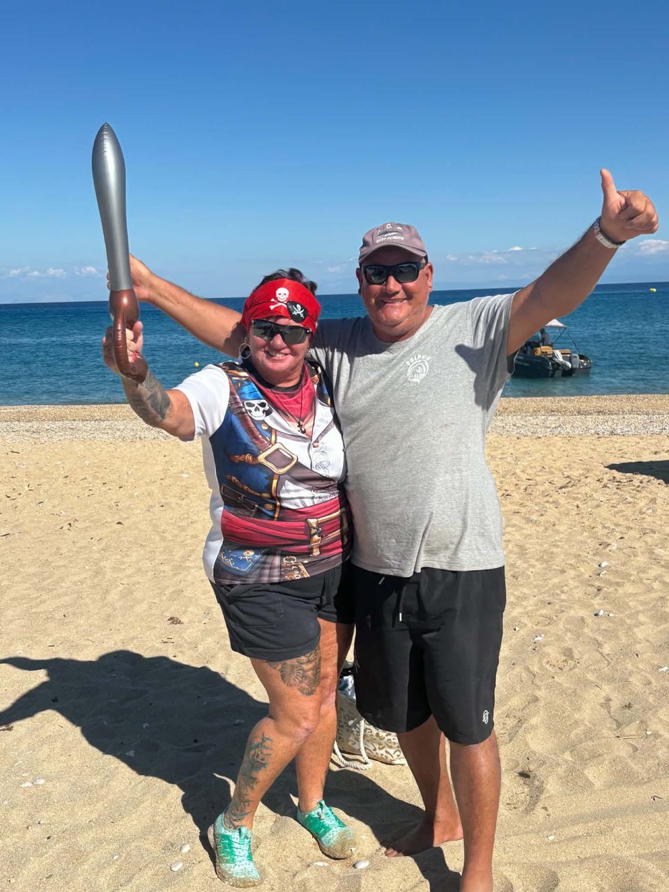 A guest in pirate costume and a Dolphin Ski Club team member cheering on Skala beach